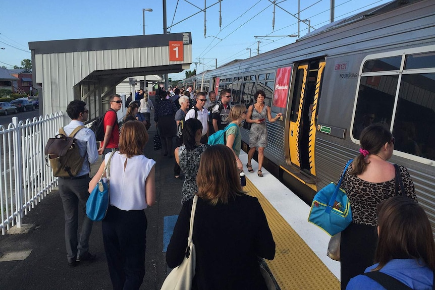 People pack onto delayed train at Deagon station, north of Brisbane, bound for CBD