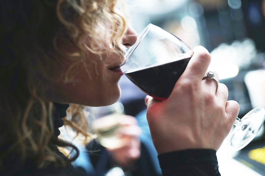 Woman drinking wine from a glass, in profile