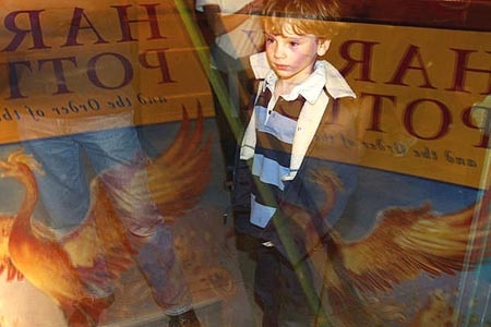 A boy waits outside an English bookshop for the latest Potter book