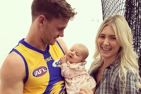 Jack Redden in his West Coast guernsey holds his baby daughter Izzy with his wife Aymee.