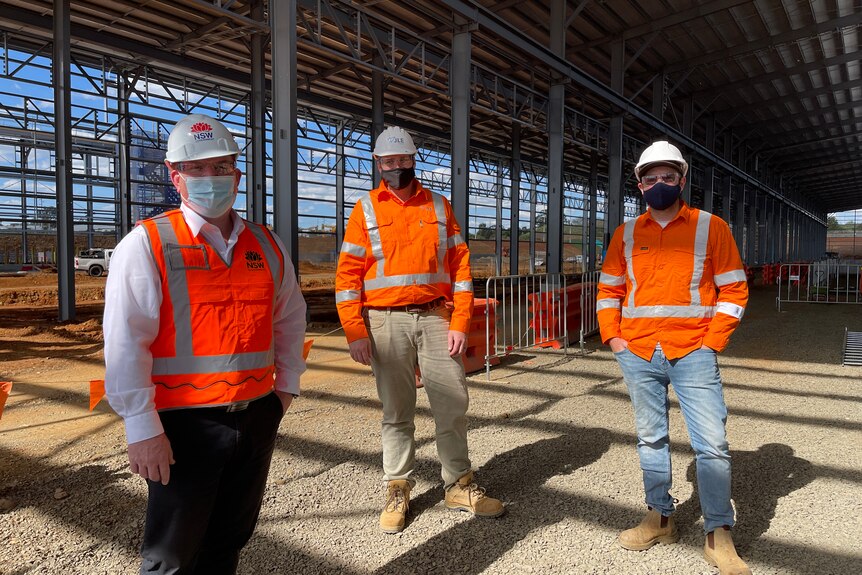 Three men in high vis at a construction site