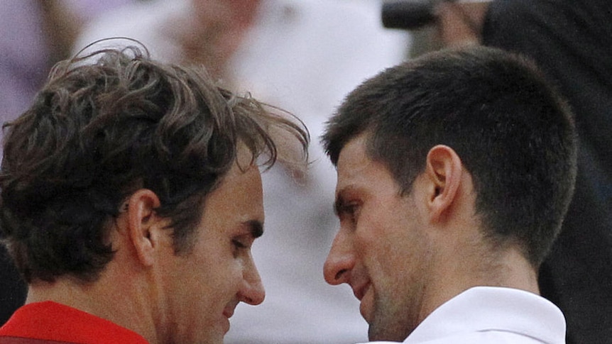 Roger Federer (L) and Novak Djokovic embrace during a semi-final at the French Open