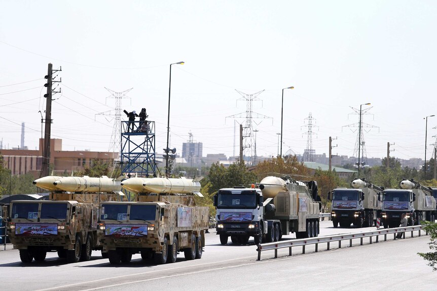 Iran's missiles are displayed by five Revolutionary Guard trucks during a military parade.
