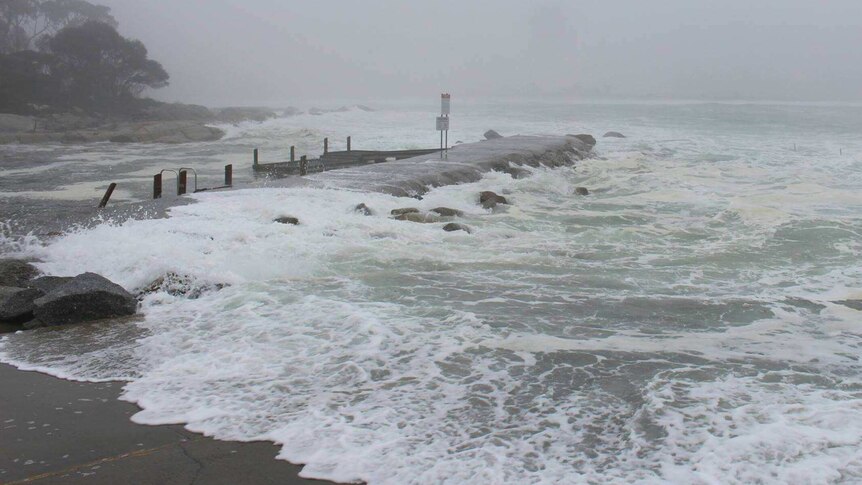 A boat ramp in Tasmania is engulfed by stormy weather and big waves.