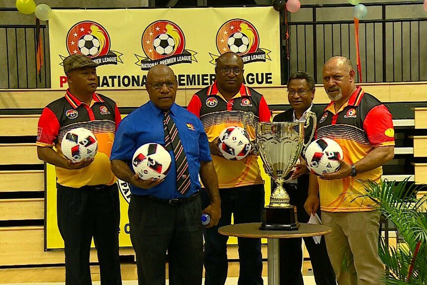 Five officials of the National Premier League stand around a trophy at the league launch.