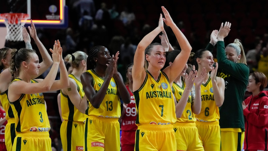 A group of Australian Opals basketballers applaud the crowd after a match at the FIBA Women's World Cup.