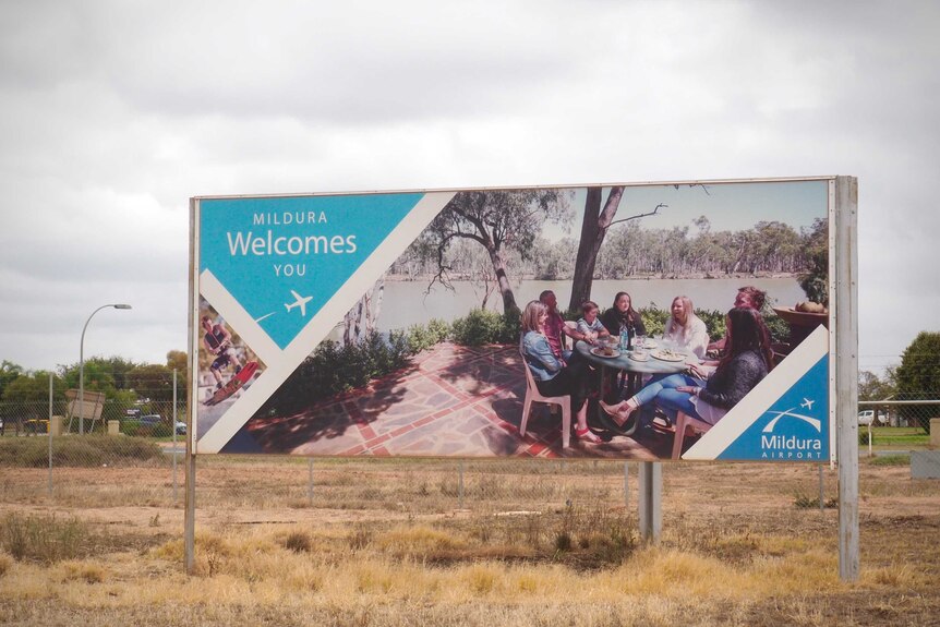 A sign that reads "Mildura Welcomes You" along with a photo of a group of people smiling outside the Mildura Airport.