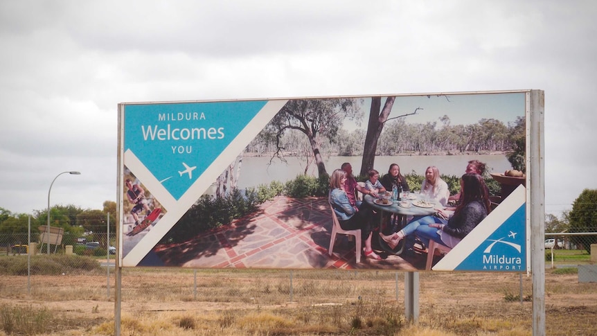 A sign that reads "Mildura Welcomes You" along with a photo of a group of people smiling outside the Mildura Airport.