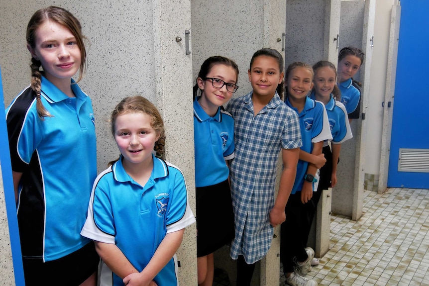 Girls at Sorrento Primary School line up against the toilet cubicles.