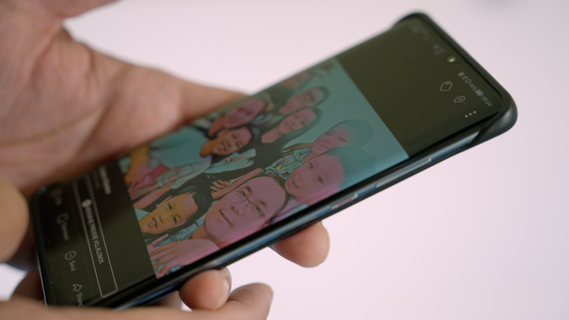 Man's hands holding phone with family photo displayed