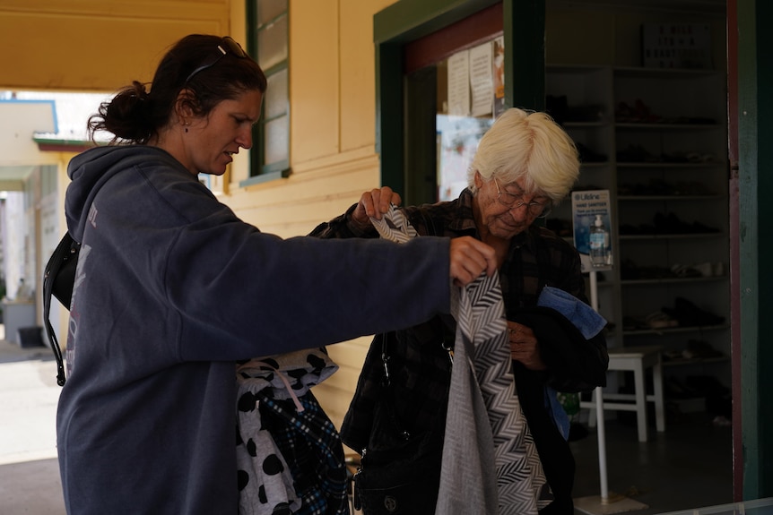 Two women look through charity items after losing their home in a bushfire.