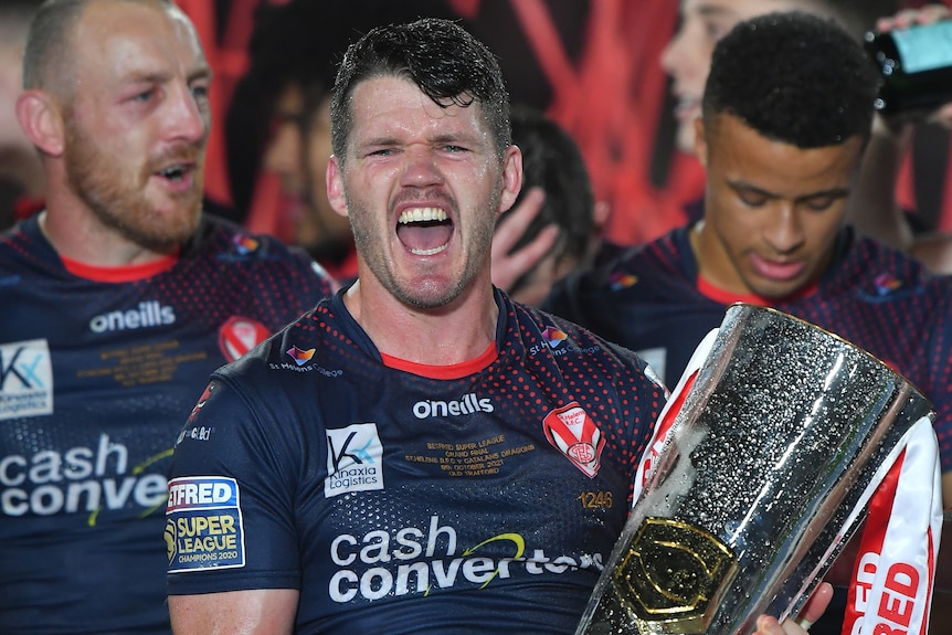 Lachlan Coote yells in celebration while holding the trophy