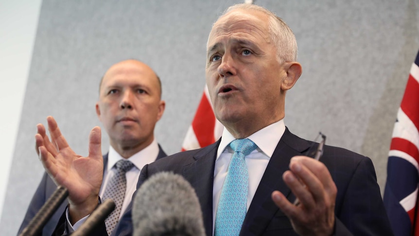 Prime Minister Malcolm Turnbull gives a speech on March 25, 2018, while Home Affairs Minister Peter Dutton looks on.