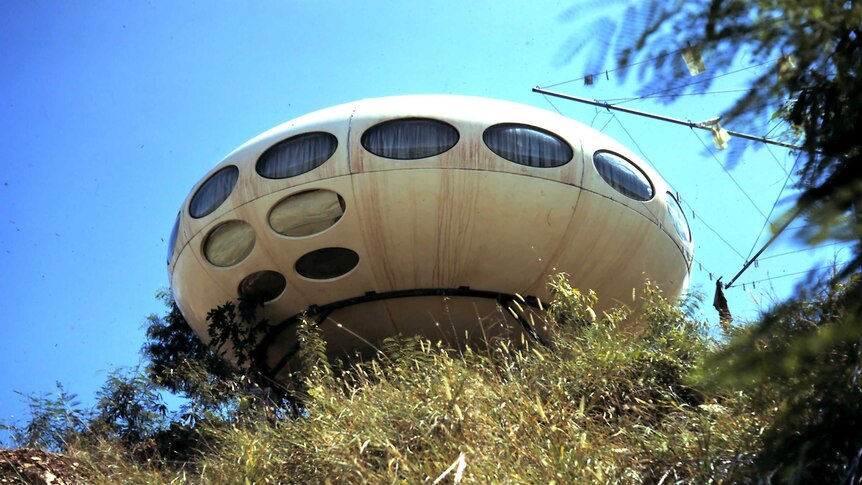A UFO shaped house on a hill.