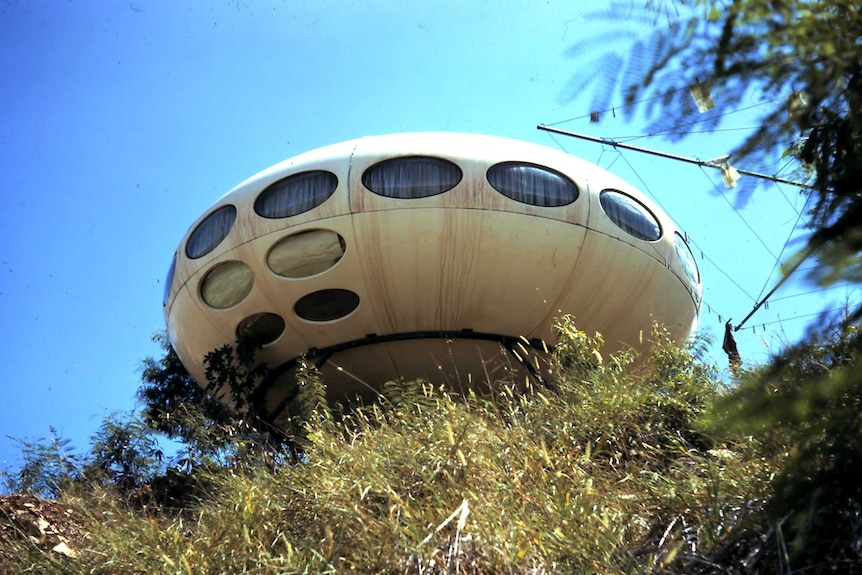 A UFO shaped house on a hill.