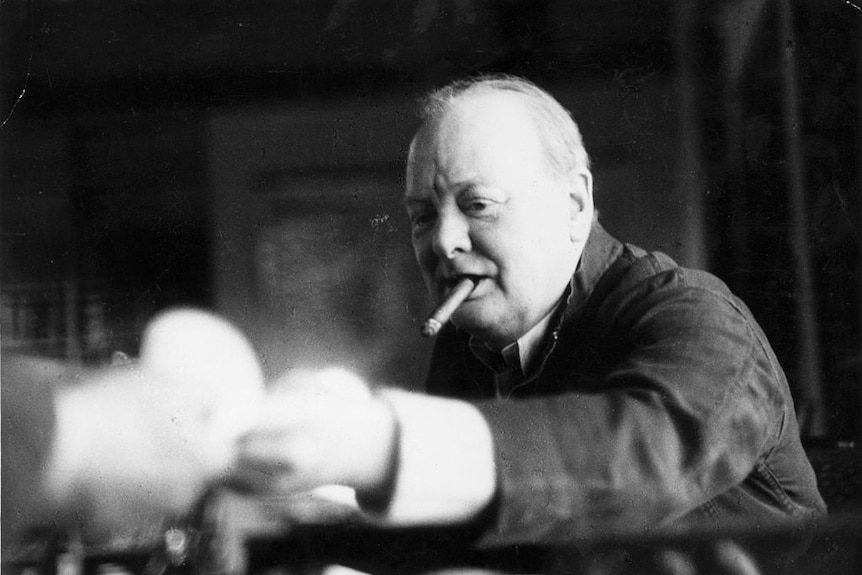 A black and white photograph of Winston Churchill smoking a cigar