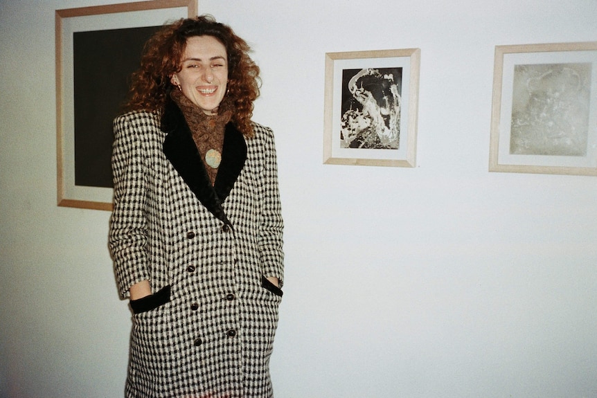 Alex Rosenblum smiling in front of her artwork.