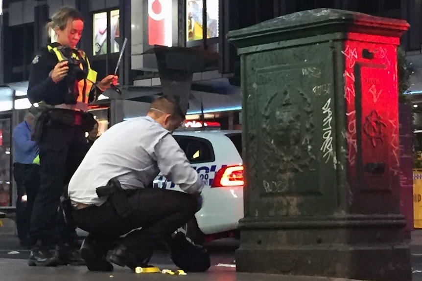Police collect evidence at Elizabeth Street, in Melbourne after two people were stabbed