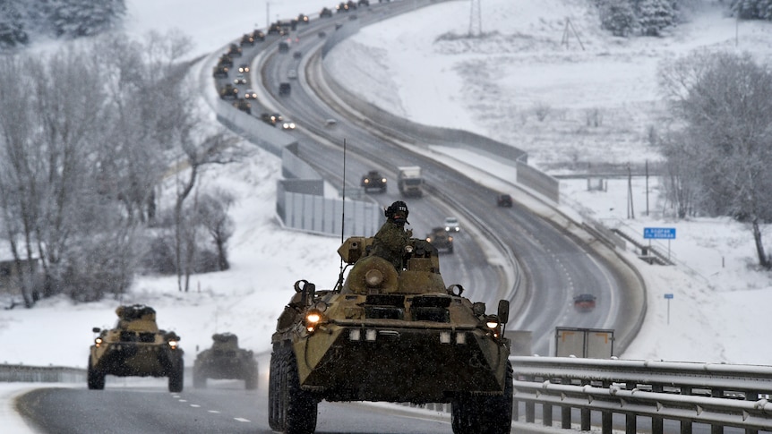 A convoy of Russian armored vehicles moves along a highway in Crimea.