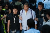 Media magnate Jimmy Lai, center, is taken away by police officers.