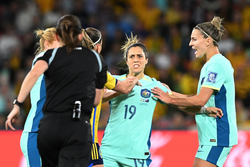 Matildas teammates hold Katrina Gorry during Australia's third-place playoff game against Sweden.