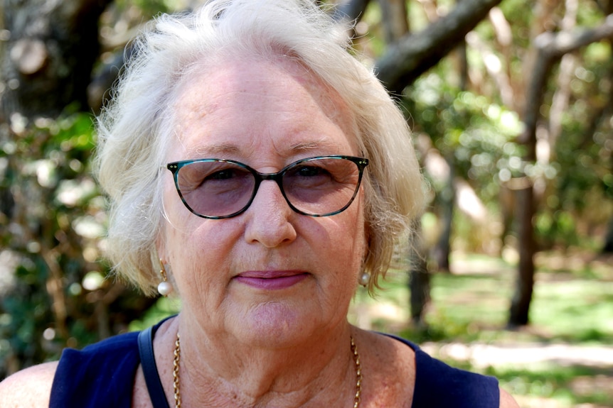 A woman with fair hair and glasses.