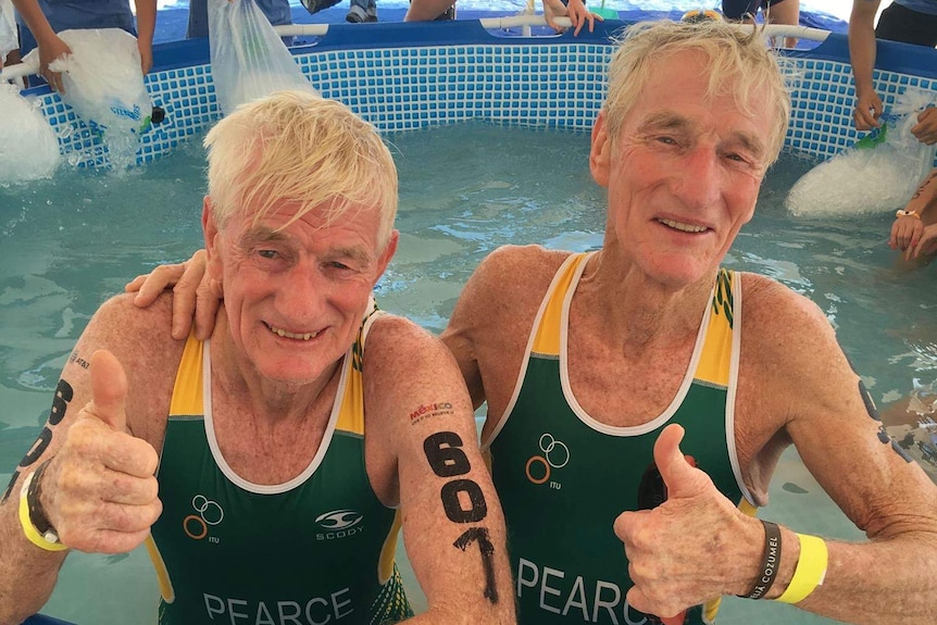 Identical twins, Keith and Frank Pearce, smiling, in an ice bath after the World Triathlon Championships in Mexico.