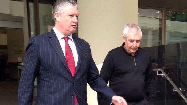 Ian Stuart McAlpine (R) with his lawyer Mark Andrews walks down steps outside a court building in Perth.