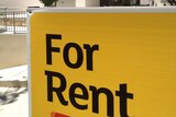 Large 'For Rent' sign outside a block of units