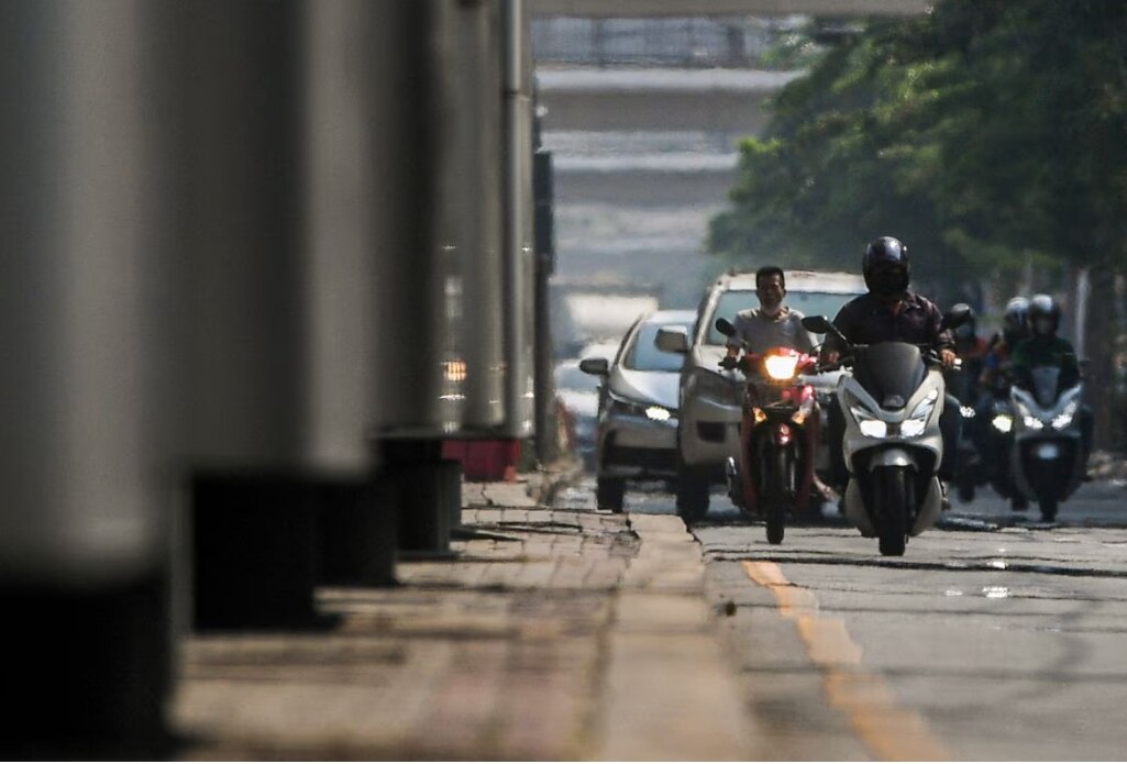 Motorbike riders are seen through heat haze in Bangkok, Thailand, in April.