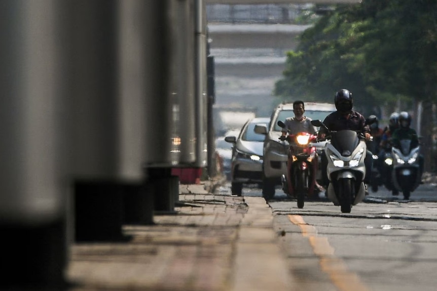 Motorbike riders are seen through heat haze in Bangkok, Thailand, in April.