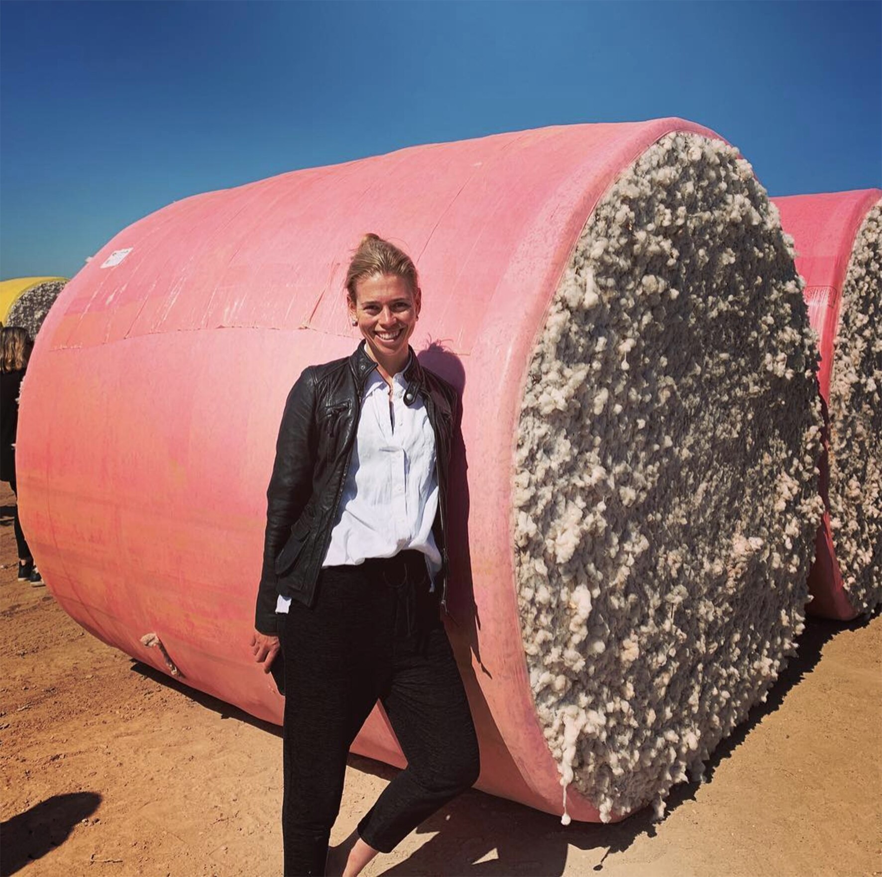Camille Reed stands in front of a bale of cotton.