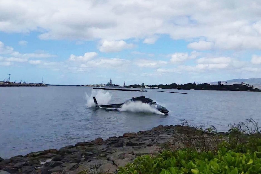 A helicopter lands in water.