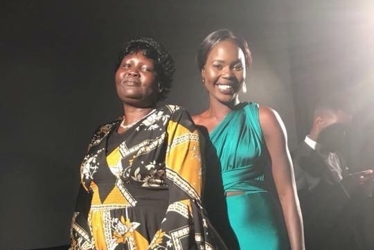 Akec Makur Chuot, dressed in a aquamarine dress, with her mother Helena Yar Enoch, a traditional African fabric dress