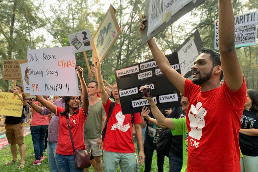 A group of Malaysians hold up signs