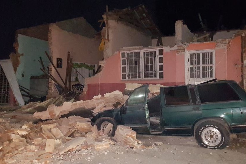 Walls and roofs of buildings are torn off, debris ruins a green station wagon in Chiapas