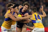 Fremantle Dockers midfielder Nat Fyfe is gang tackled by four West Coast Eagles players as he tries to handpass the ball.