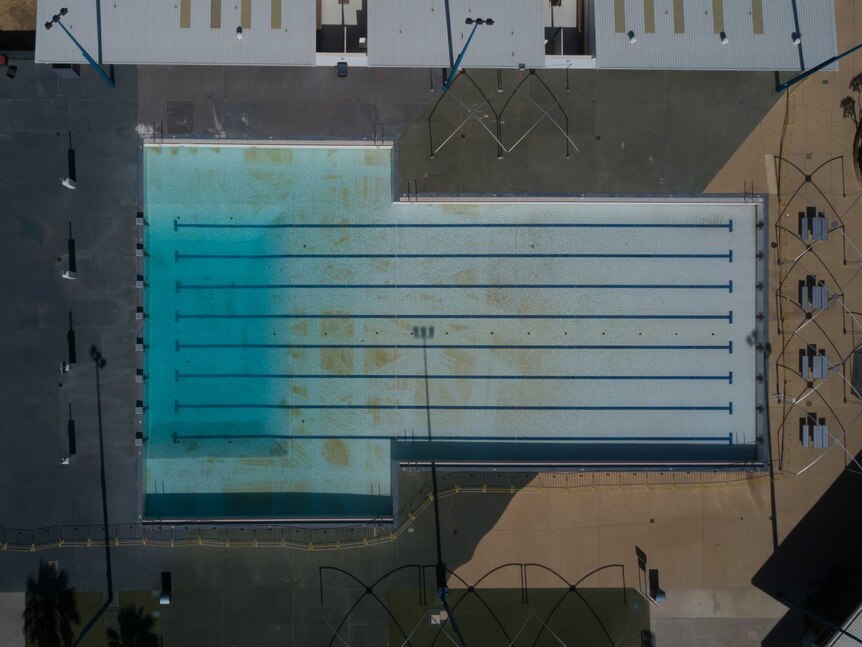 A drone image looks down on the outdoor pool where cleaning tracks can be seen on the pool floor