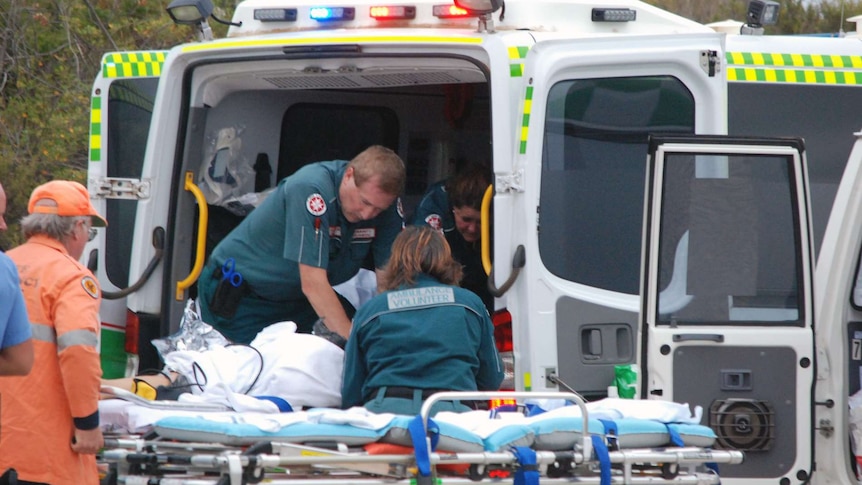 Paramedics work to try to save the young shark attack victim.