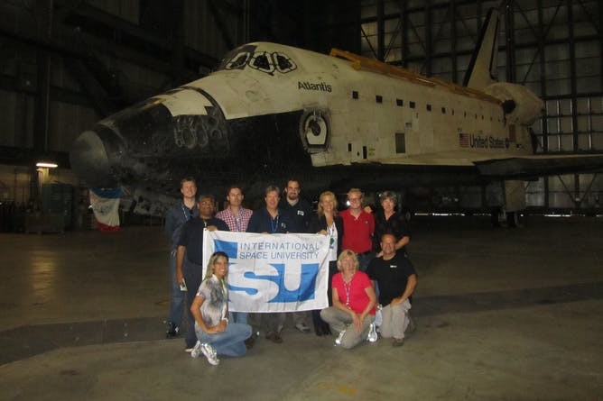 Gli studenti della International Space University posano davanti allo shuttle Atlantis al Kennedy Space Center della NASA