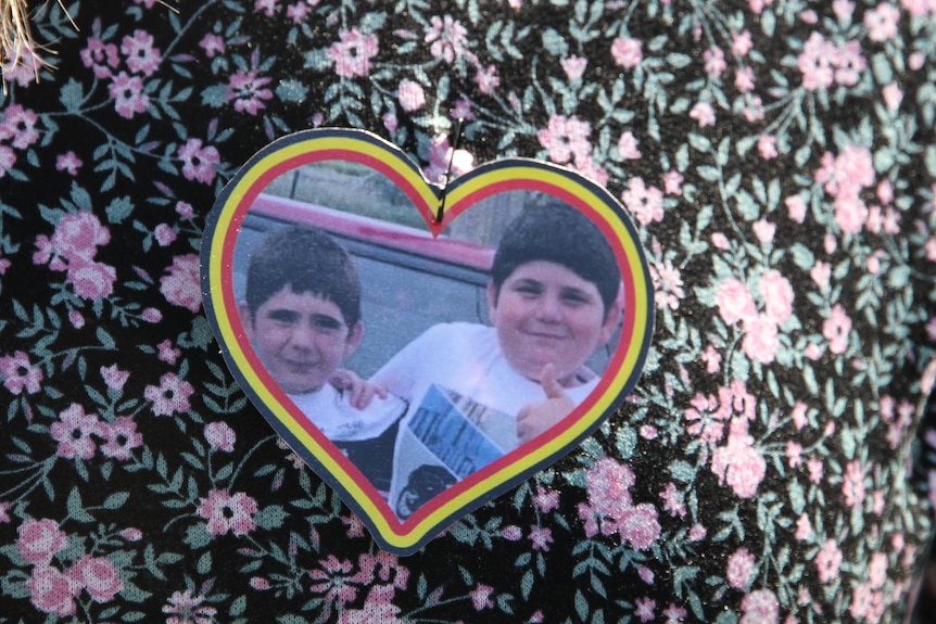 Picture of Nathaniel and Jeremiah Schmetzer on a heart shaped badge pinned to a mourner