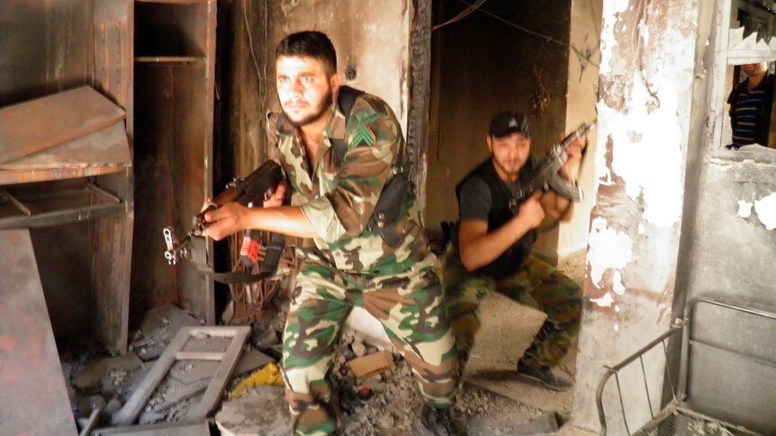 Members of the Free Syrian Army take part in a military exercise inside a damaged and abandoned building in Khalidiya.