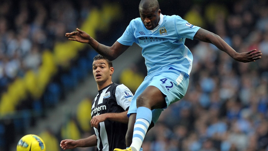 Manchester City's Yaya Toure gets to the ball before Newcastle United player
