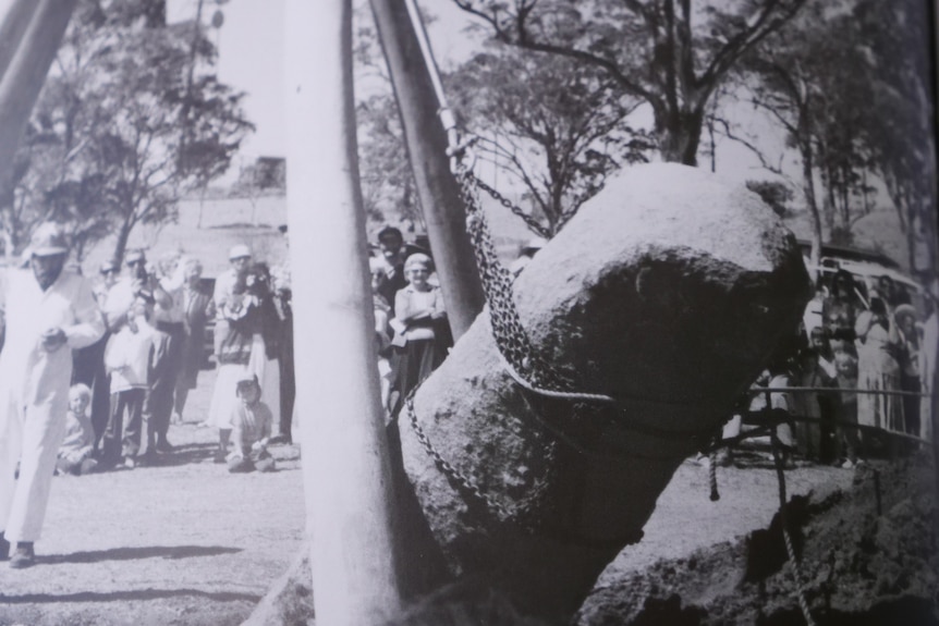 Black and White image of a block and tackle rig raising a granite stone