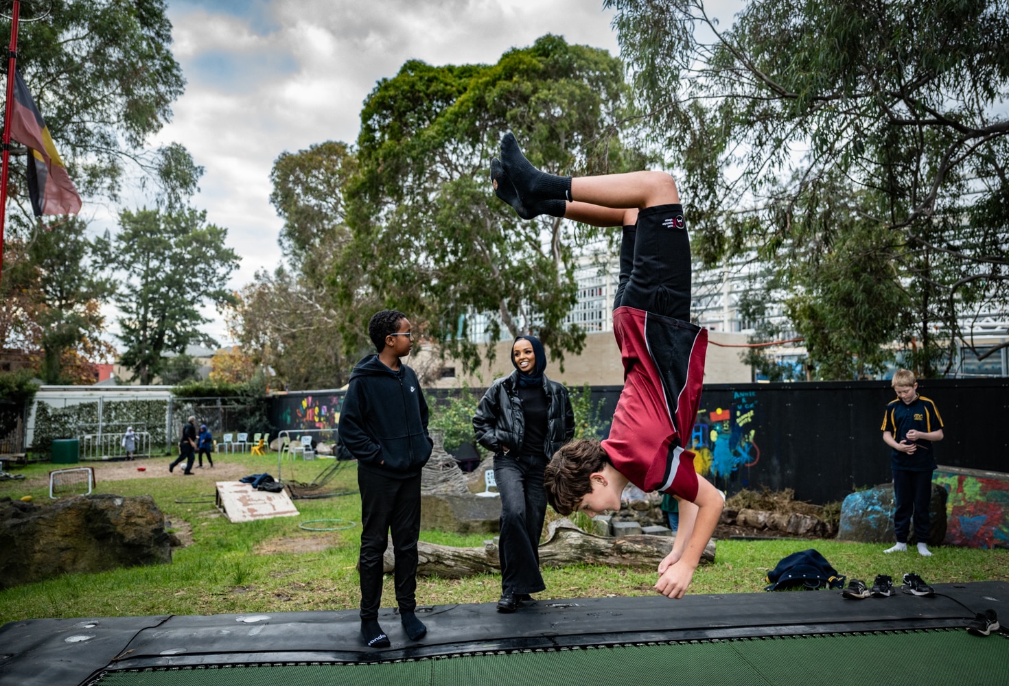 A young white boy doing a backflip on a trampoline