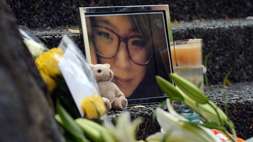 Flowers around a framed photo of 22-year-old student Eunji Ban, who was killed in Brisbane's CBD.