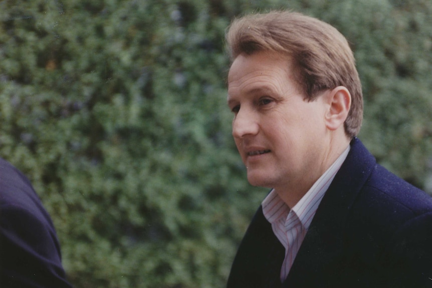 A young Tony Madafferi, photographed in profile, wearing a dark coat and white shirt with red and blue stripes.