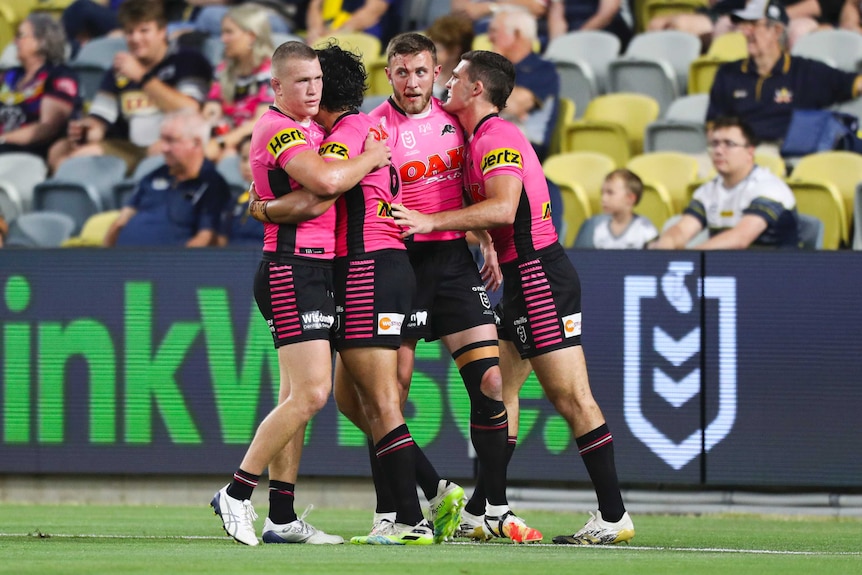 Four Penrith Panthers NRL players embrace as they celebrate a try against the North Queensland Cowboys.