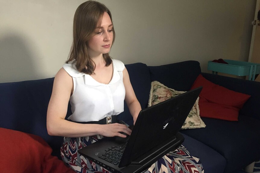Ailinn Baldassi-Winderlich sitting on a sofa working on a laptop