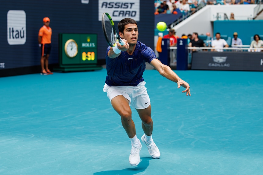 A Spanish tennis player lunges to his right and reaches out his racquet to hit a forehand return as he watches the ball.